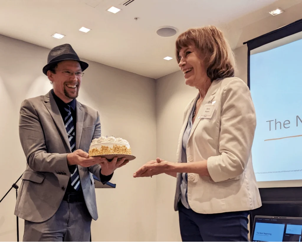 20 Years of Impact 31 Rob Williams presenting a cake to Maria Meyers for SourceLink's 20th anniversary